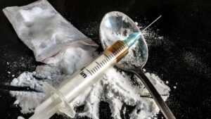 Drug syringe and cooked heroin on spoon